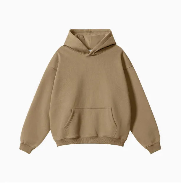 Man wearing a loose grey hooded terry cotton sweater with drop-shoulder sleeves.