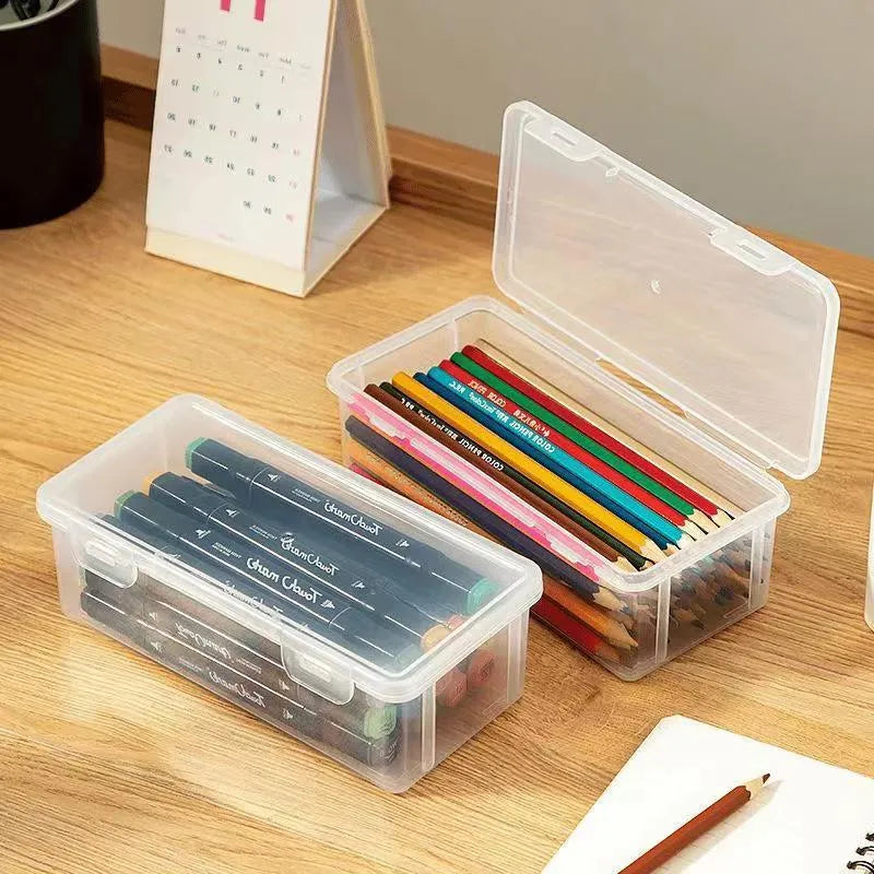 Transparent plastic stationery storage box containing pencils and colour crayons