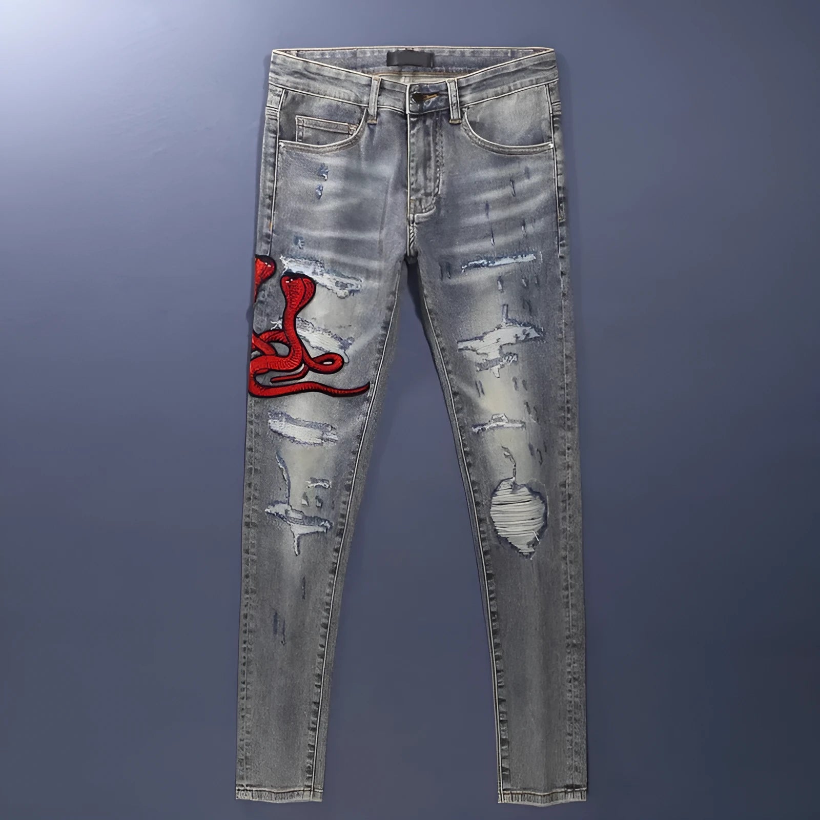 Worn looking washed-out slim fit jeans with hole patches and embroidered brand detail in old colour