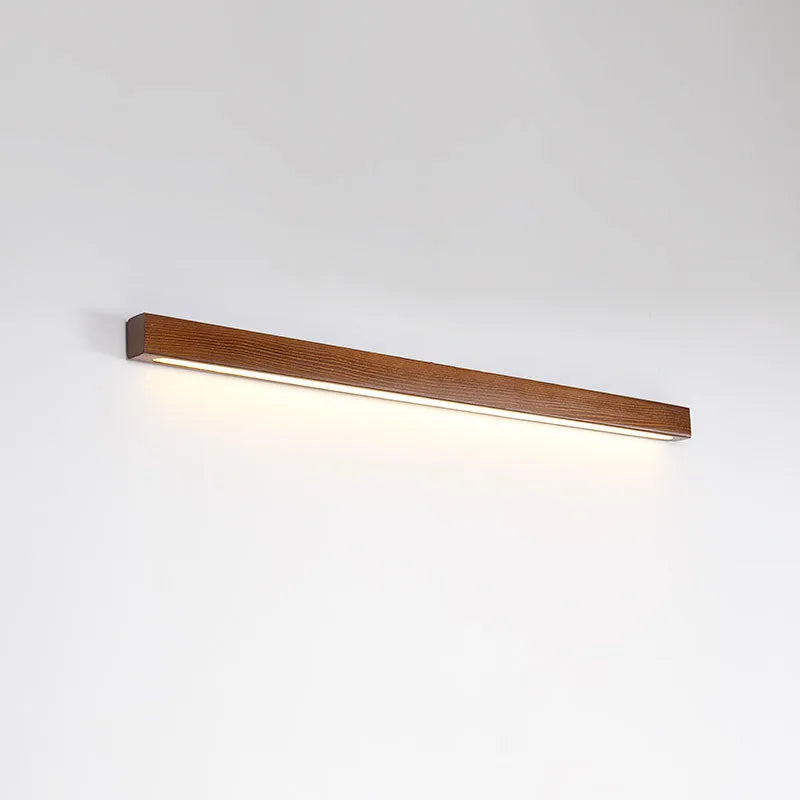 Walnut colour wood and acrylic wall lamp strip with LED lighting in a minimalist design on a wall.