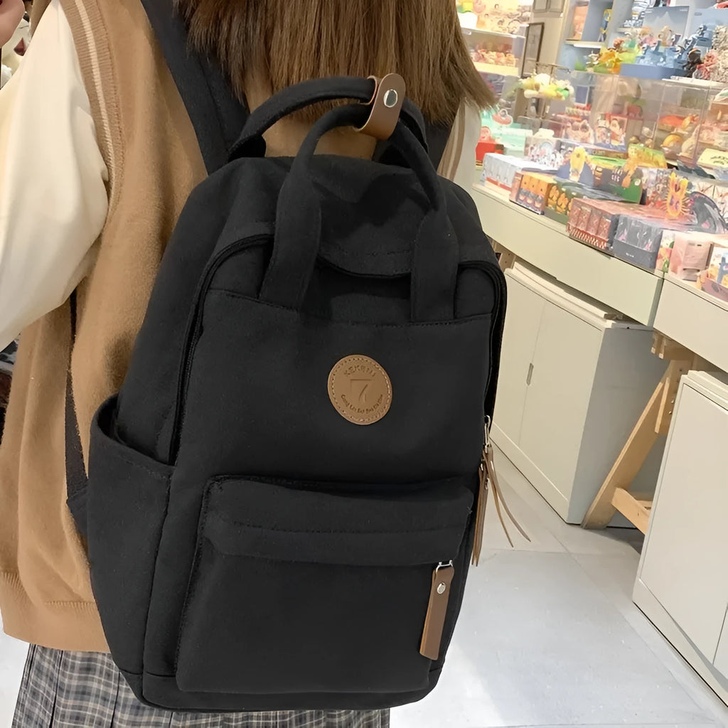 Black Oxford cloth backpack with curved shoulder straps and retro urban style detailing