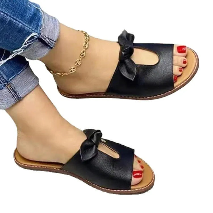 Ladies casual sandals with fish mouth front and decorative bow in black, pink, and gold colours.