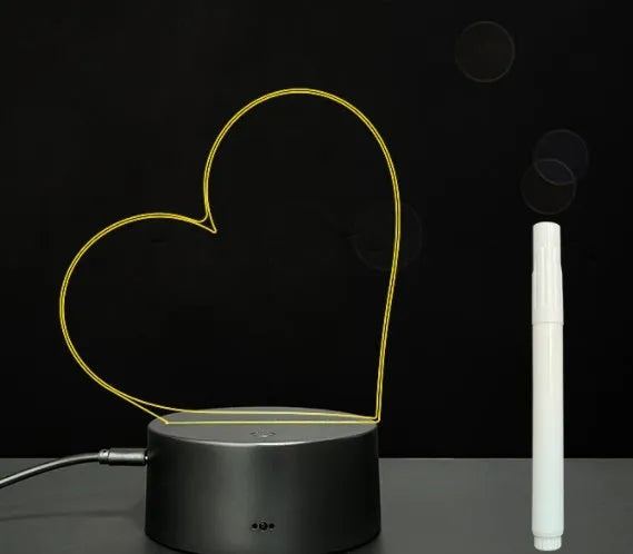 Black 3D LED handwritten acrylic message board with remote control on a desk.
