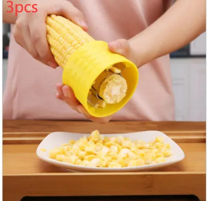 Yellow manual corn thresher with corn-shaped design and stainless steel gear for peeling kernels.