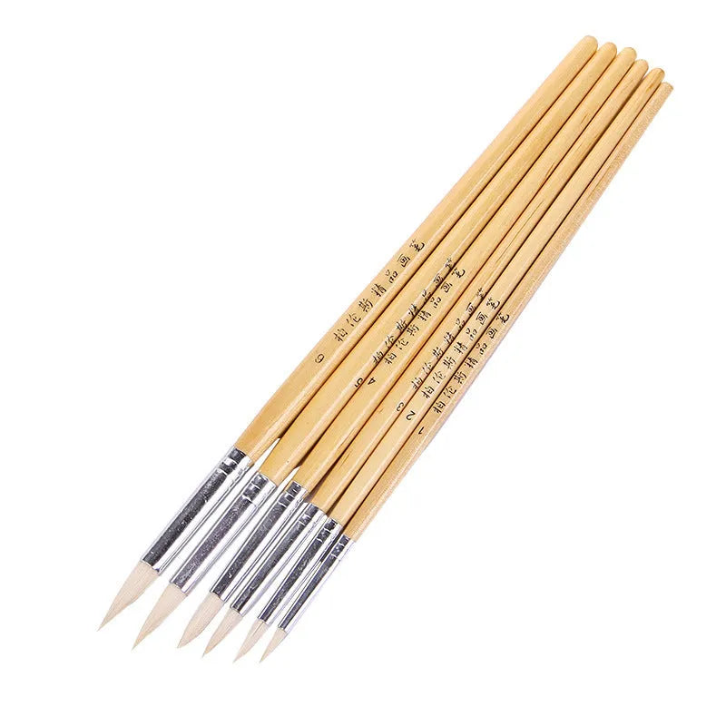 Six wooden-handled artist brushes with pointed wool tips arranged together.