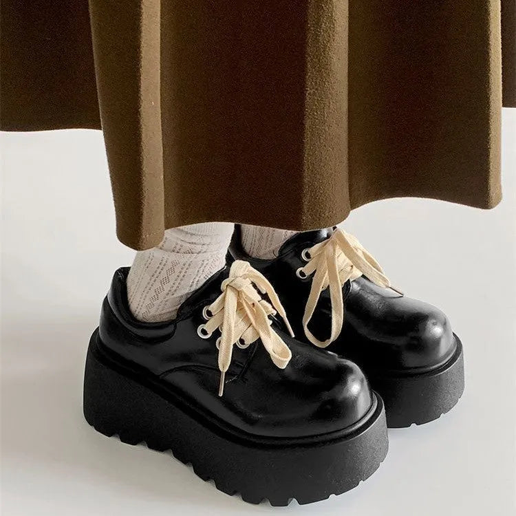 Black women's lace-up platform shoes with a chunky rubber sole and English muffin heel.