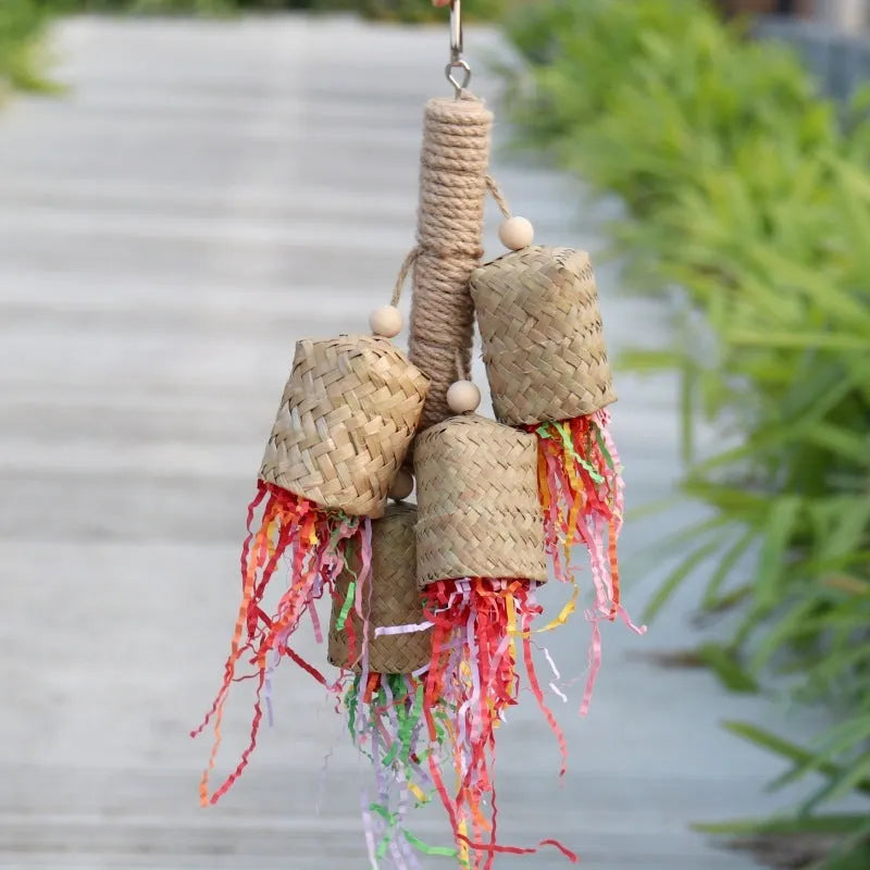 Wooden parrot toy with colourful shredded paper hanging by sisal rope