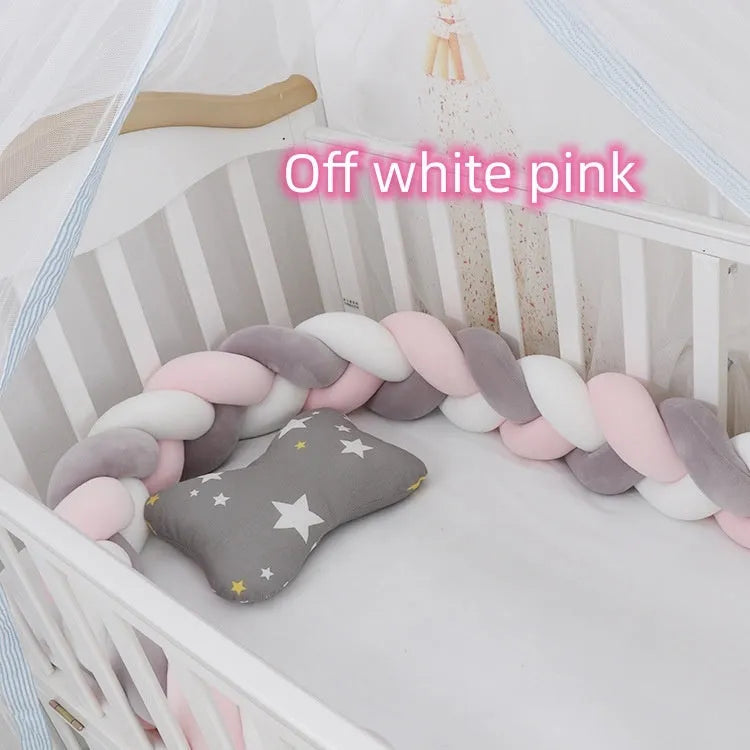 Braided knot baby crib bumper in spandex velvet wrapped around white cot rails.
