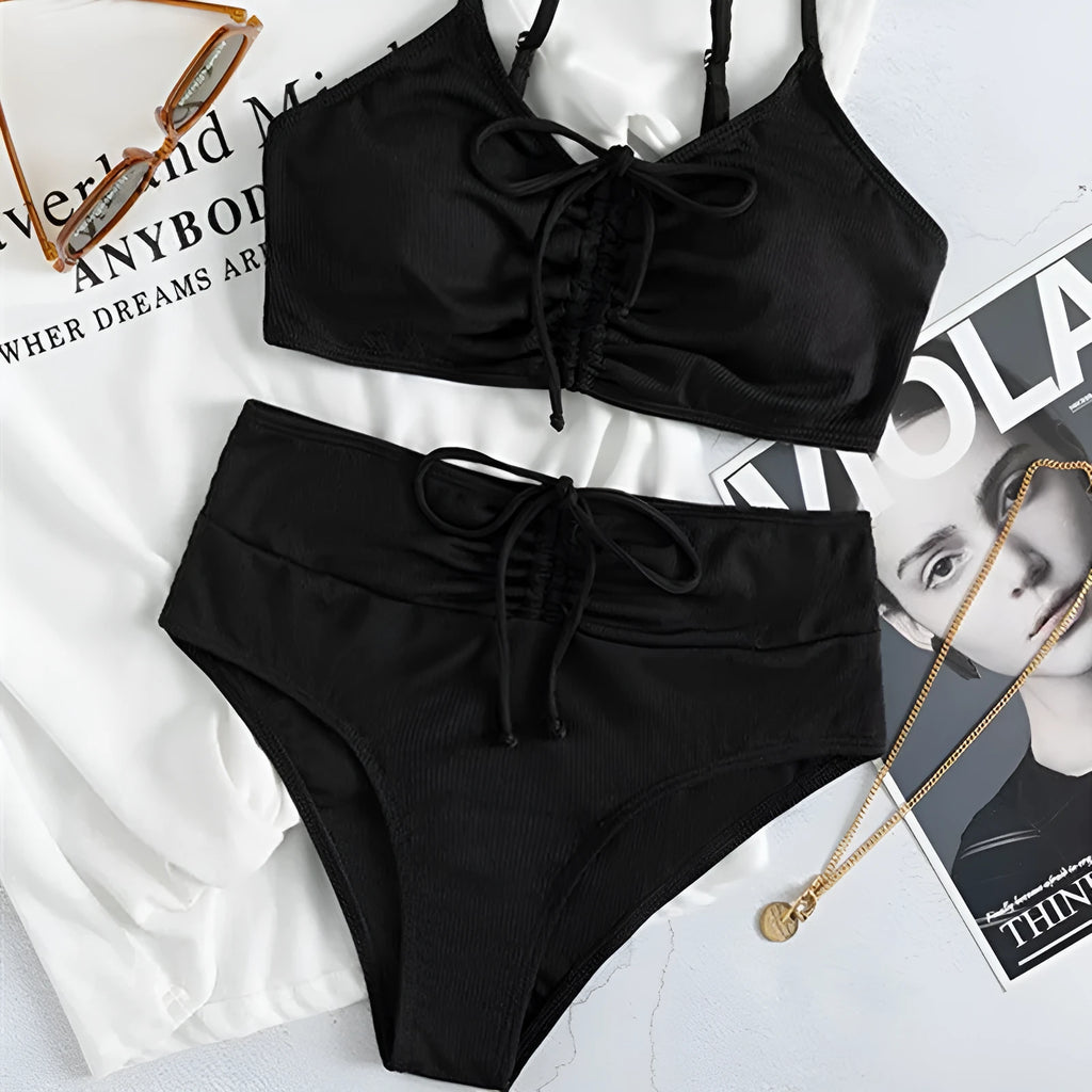 Black women's high-waist bikini with sling split design on shorts and sleeveless top.