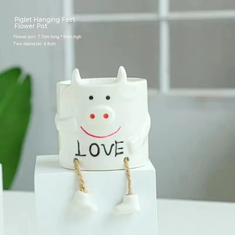 Cartoon style ceramic hanging foot flowerpot for succulent plants on a desktop.