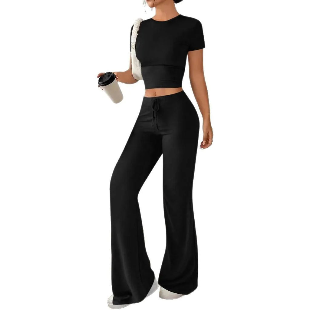 Black women's high waist trousers and short sleeve t-shirt co-ord set laid flat.