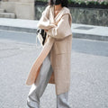Long grey knitted hooded cardigan trench coat on a hanger, showing loose fit and long sleeves.