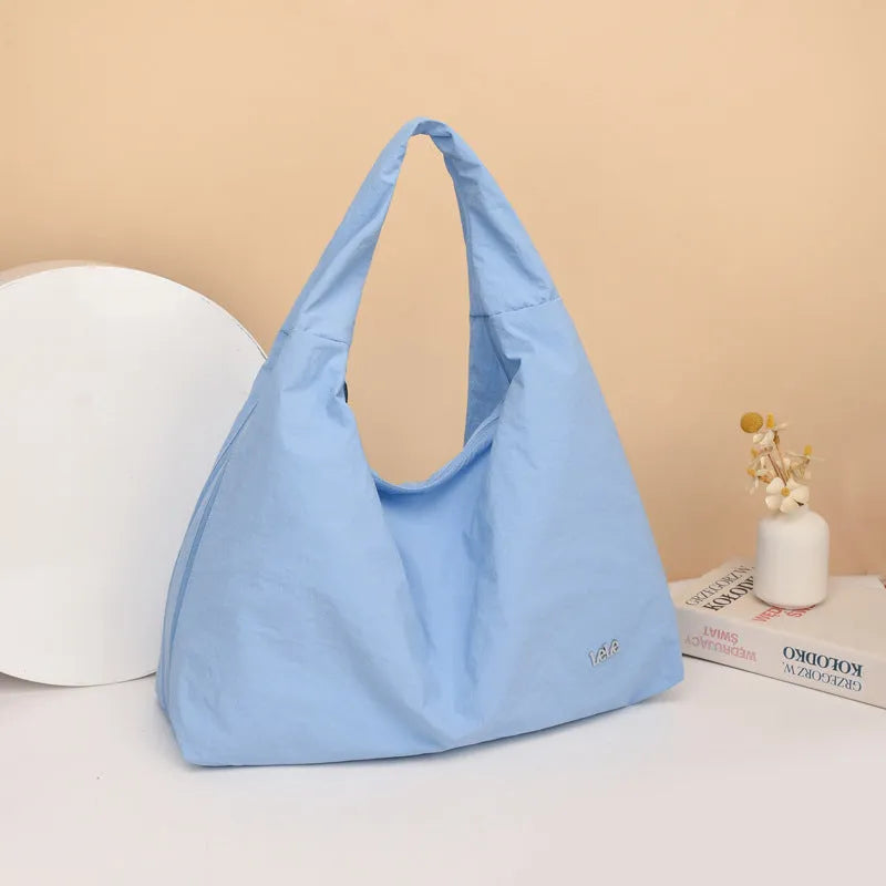 Nylon underarm bag with heart shape design in four colour options showing large capacity interior