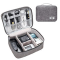 Black travel cable organiser bag open, showing mesh pockets, elastic loops, and removable padded dividers inside.