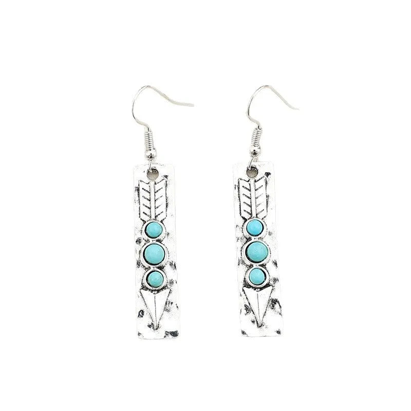 Geometric long silver earrings with blue turquoise inlay detail on a white background.