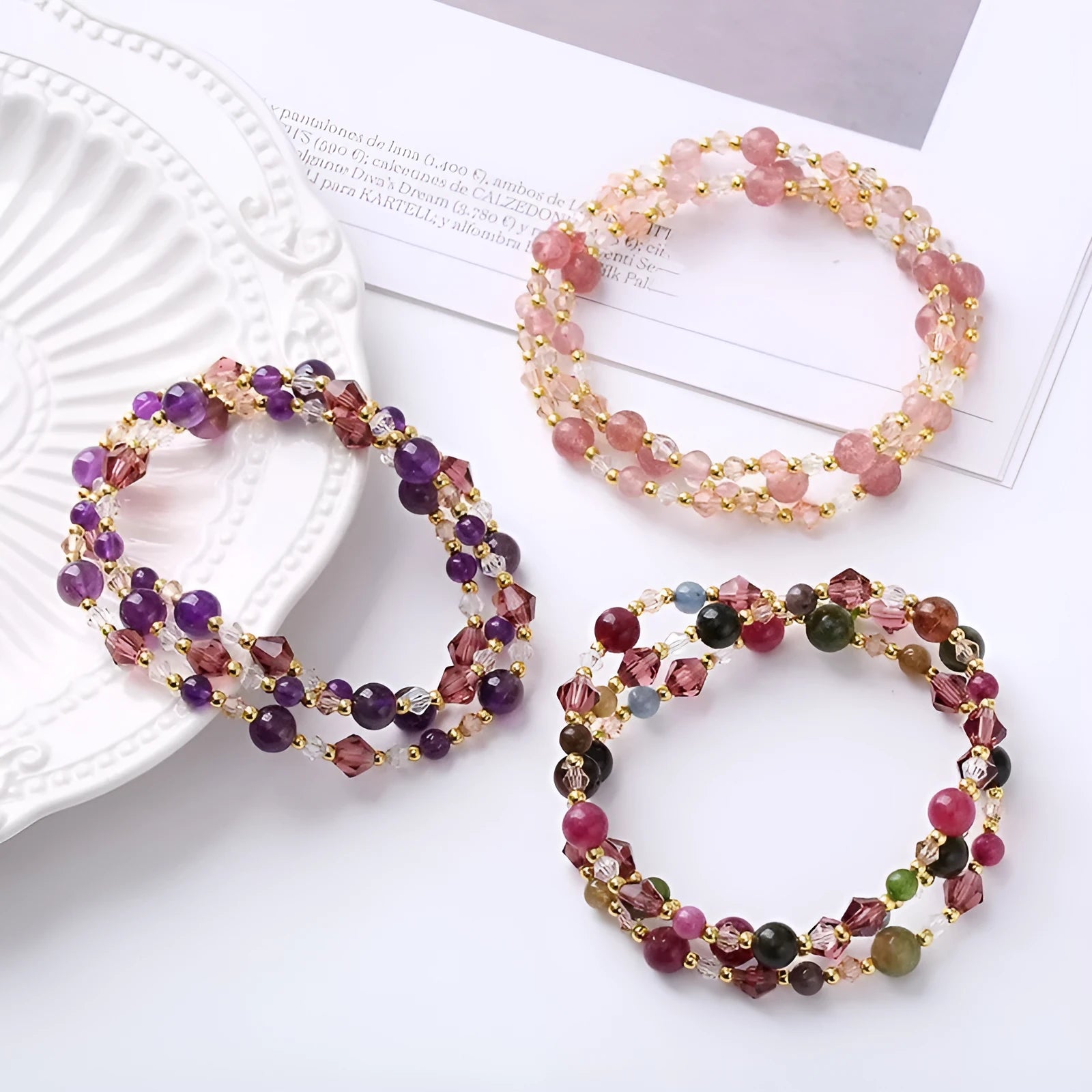 Colourful three-ring crystal bracelet with tourmaline, strawberry quartz, and amethyst beads on an adjustable cord.