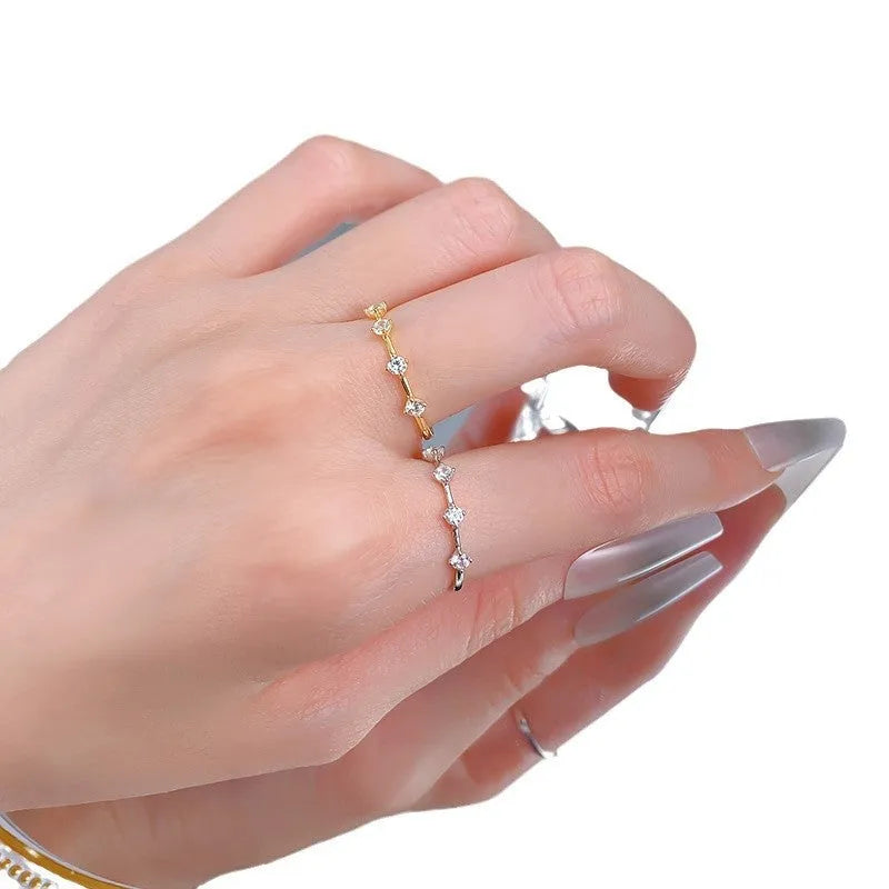 Gold electroplated minimalist ring with a row of small diamonds on silver band