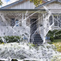 White cotton Halloween spider web decoration draped with plastic spider props.