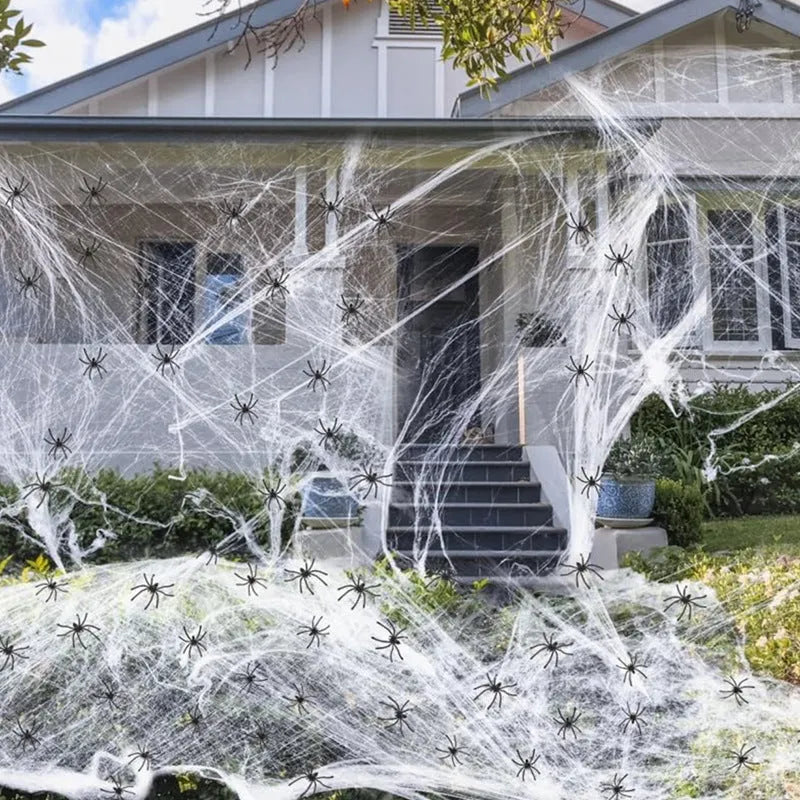 White cotton Halloween spider web decoration draped with plastic spider props.