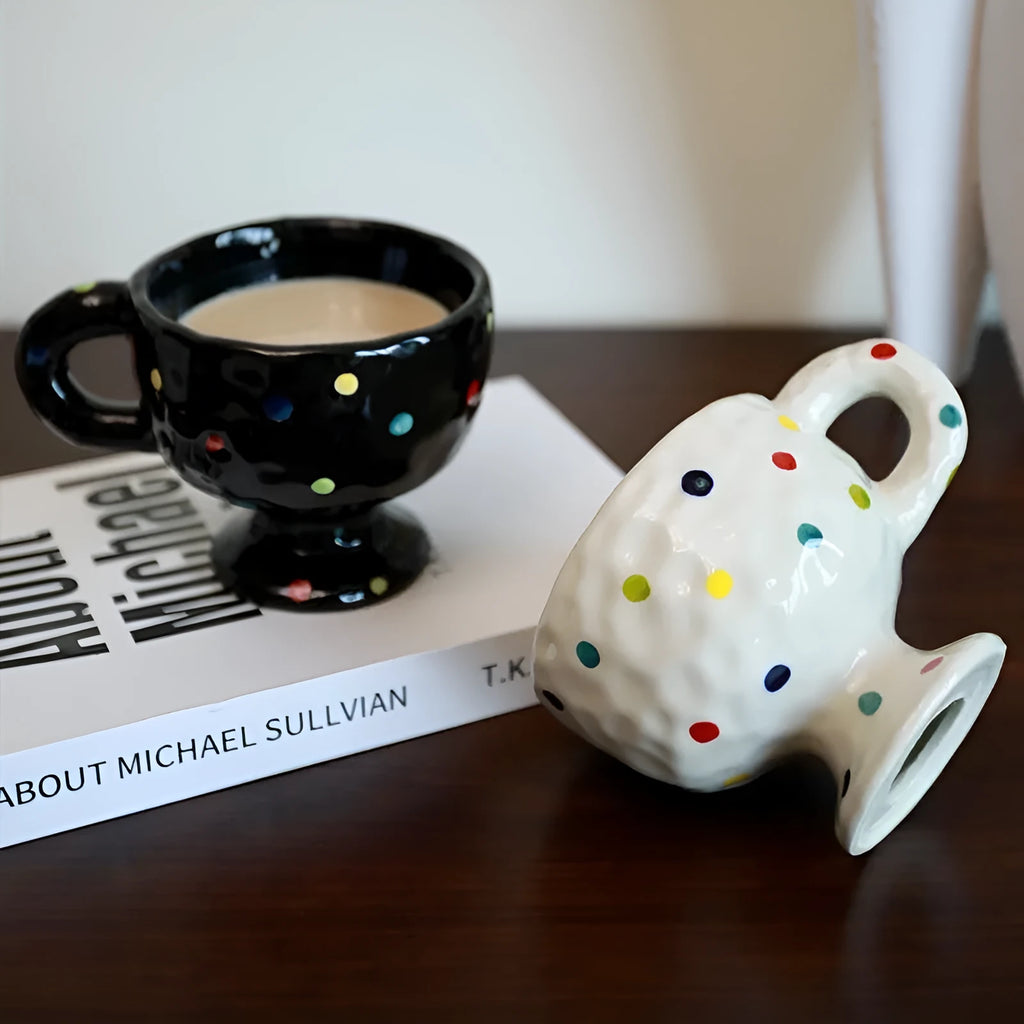 Hand-pinched irregular shaped ceramic mug in a solid colour on a table.