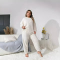 Women's creamy white polyester two-piece lounge set with long sleeve top and trousers on a hanger.