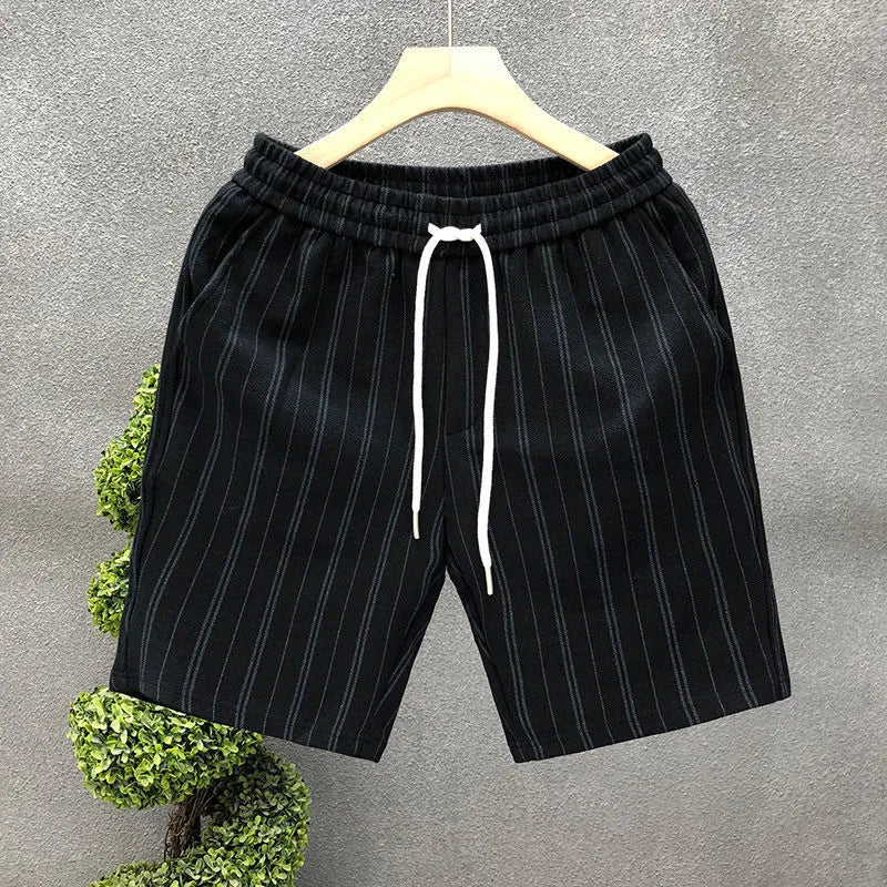 Men's black and white striped fleece-lined casual shorts with an ankle-banded cuff on a hanger.
