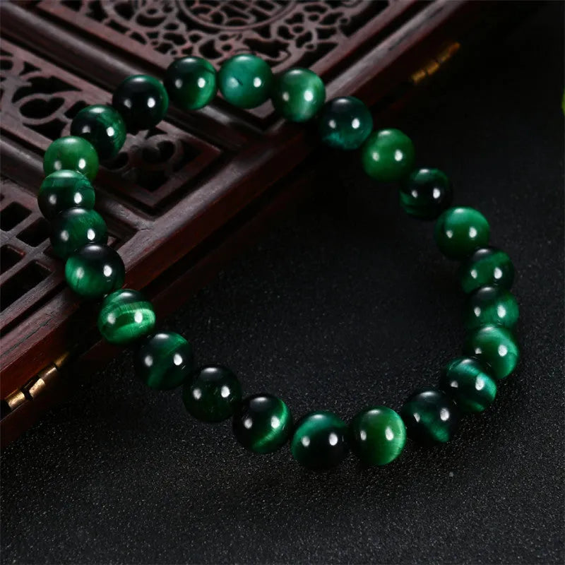 Green Tiger Eye stone beaded bracelet showing polished geometric beads on a wrist.
