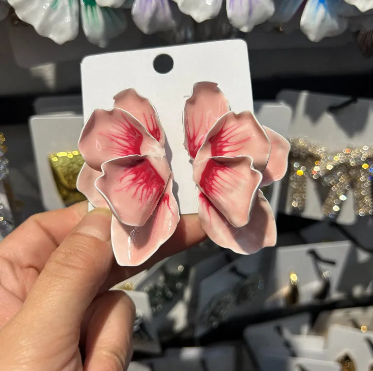 Close-up of pastoral style alloy flower stud earrings with oil-spot glaze in blue, green, purple, and rose colours