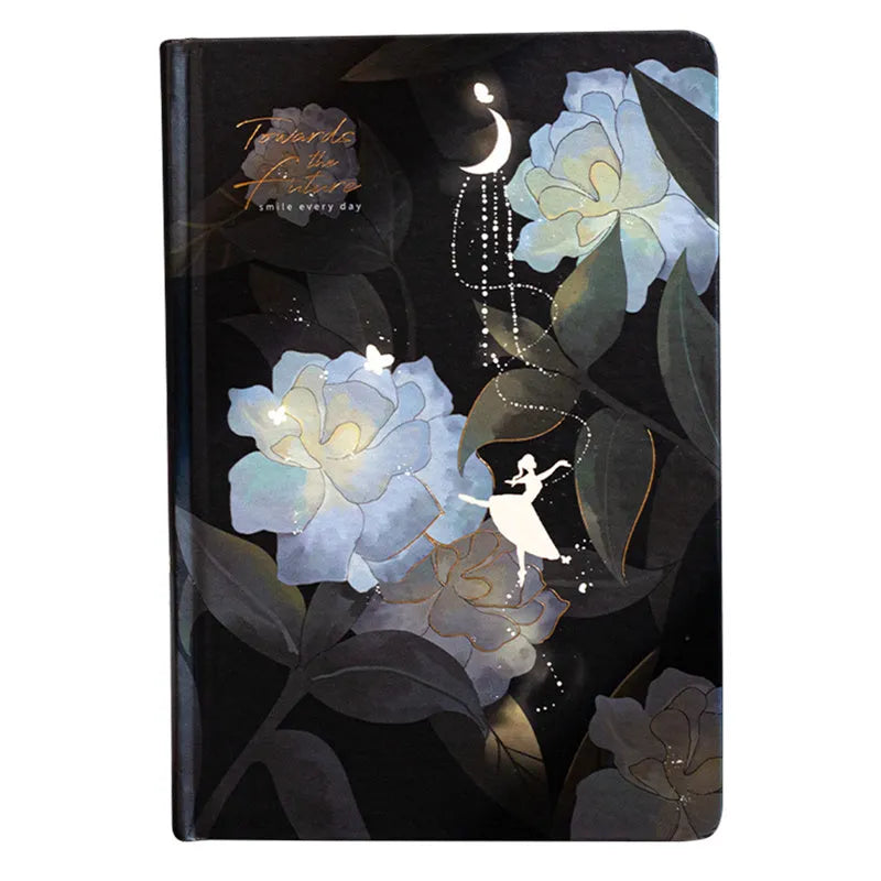 A5 notebook with luminous cover in deep blue, open to show lined pages with colour illustrations.