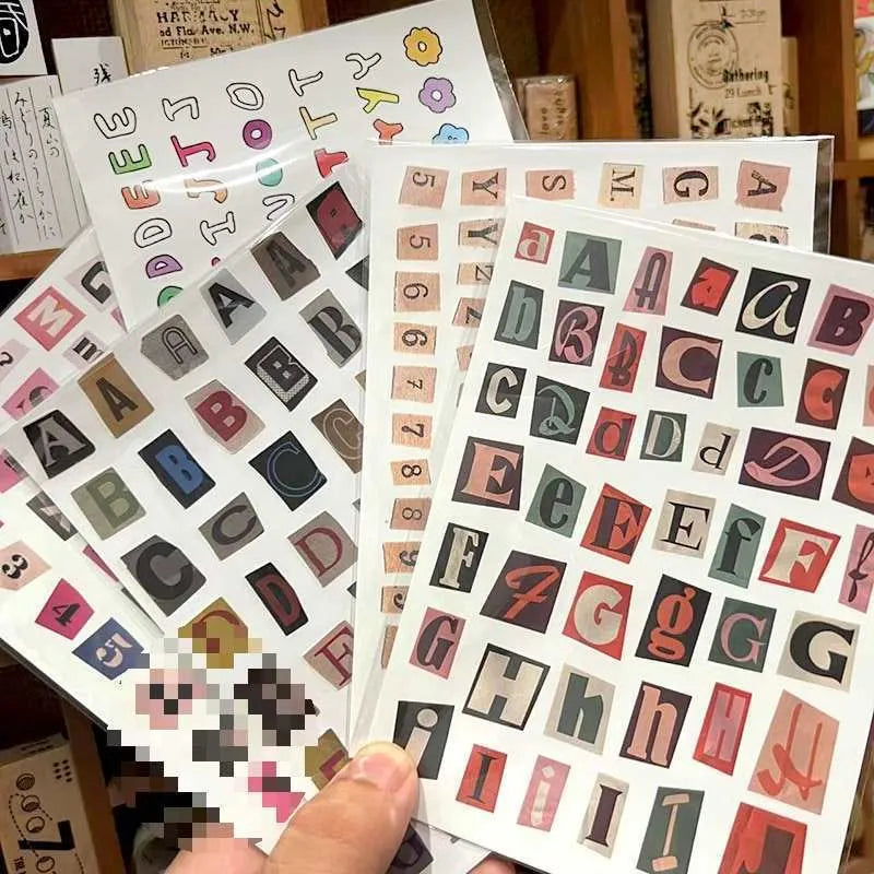 Set of printed cute style decoration stickers showing English letters, numbers, and weekly words on sheets.