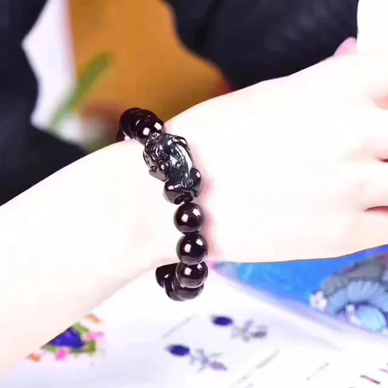 Natural ice colour Eye Obsidian crystal beaded bracelet on a wrist, showing round beads.