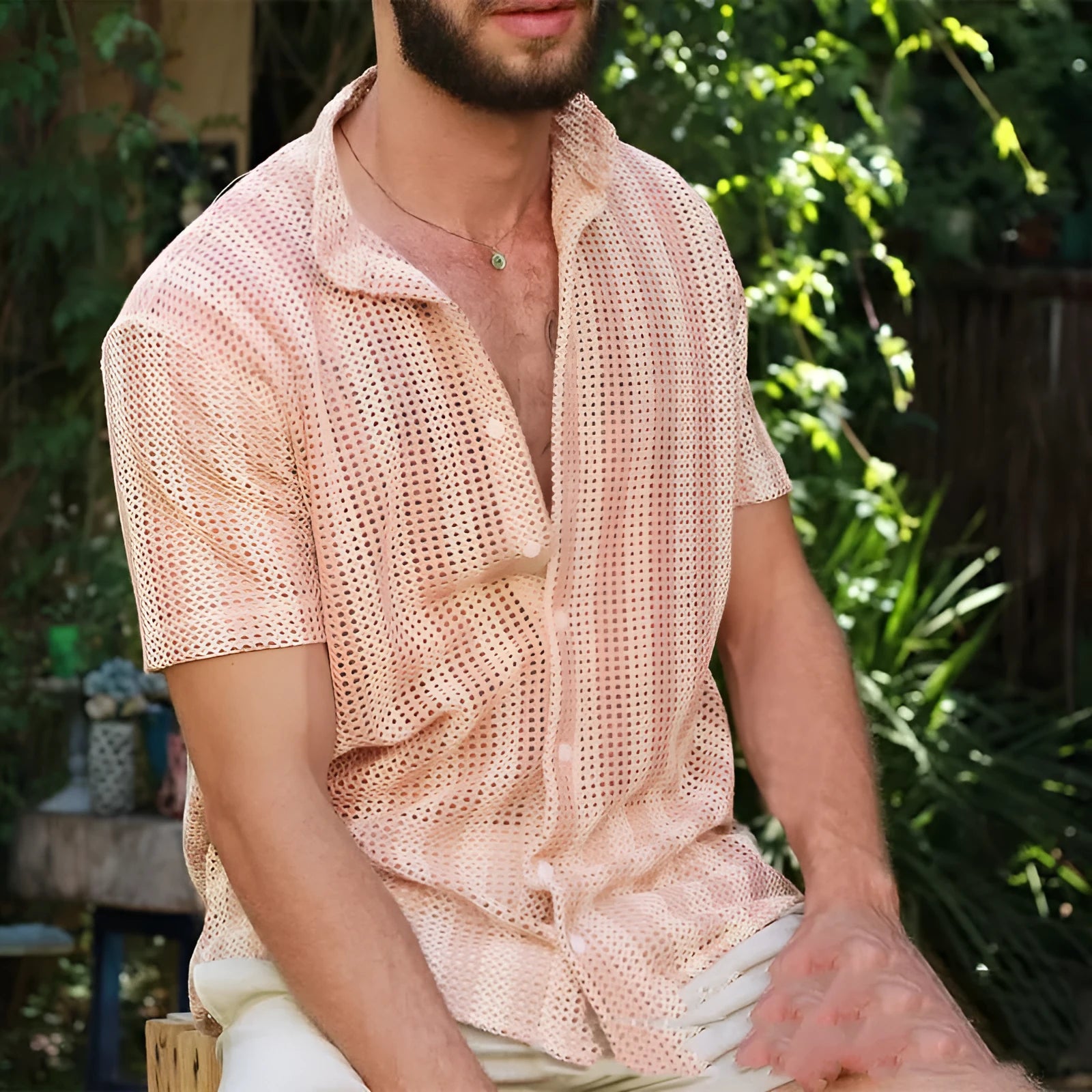 Men's pink loose-fit cardigan with a waffle texture and unique hole design detail.