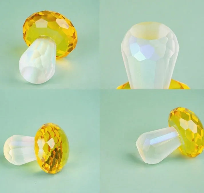 Set of four colourful crystal mushroom decorations in transparent, green, red, and yellow on a white background.