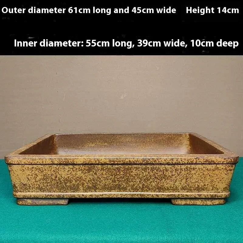 Straight-sided shallow rectangular Yixing flowerpot made from purple Zisha clay on a floor.