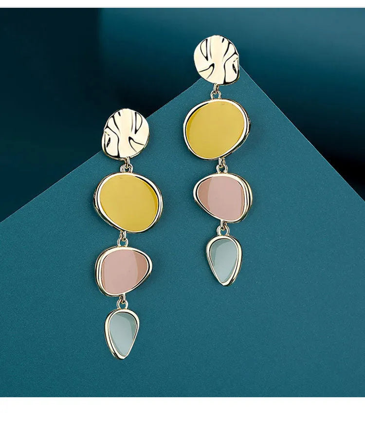 A pair of simple disc-shaped alloy earrings with a blended Morandi three-colour oil drip finish.