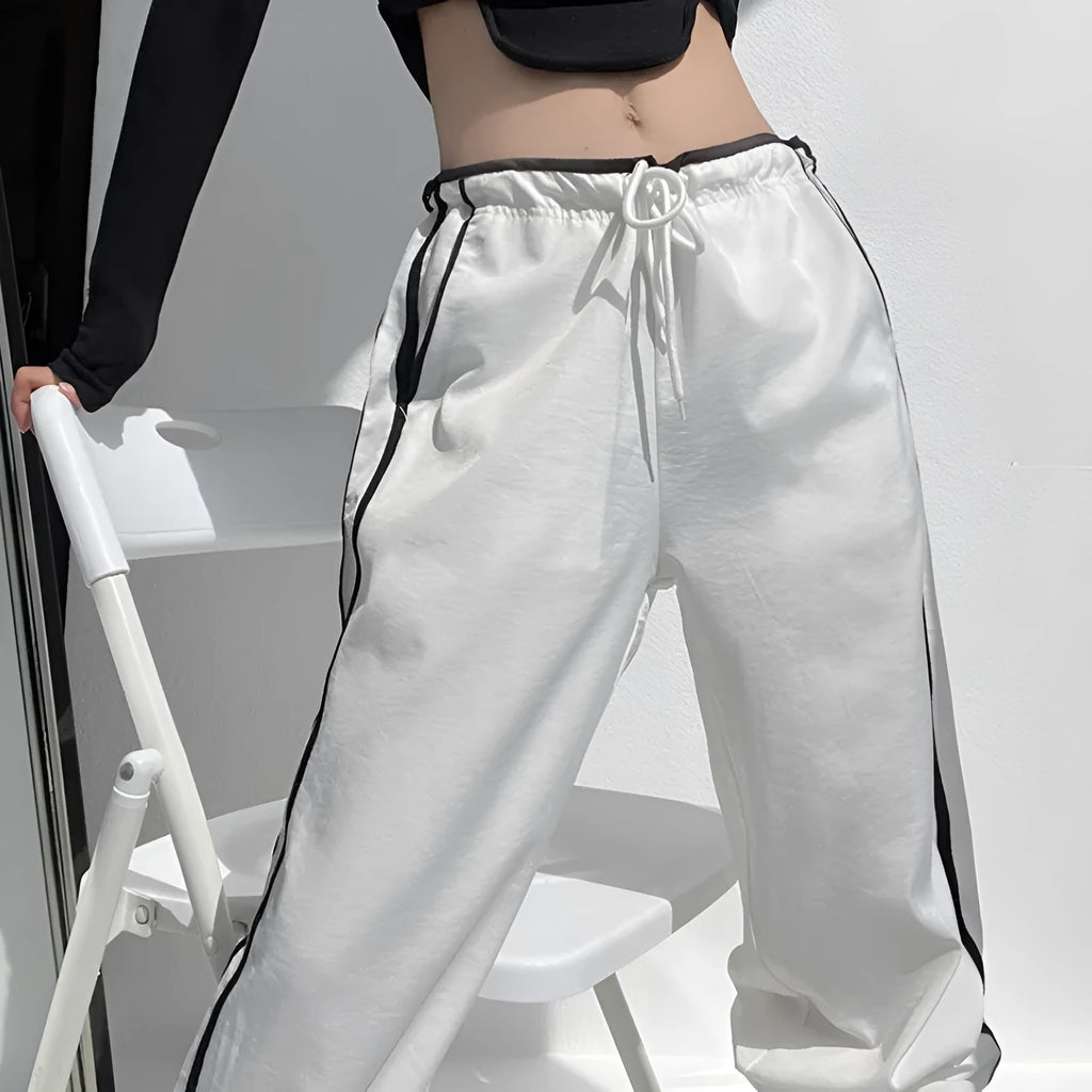 Navy blue loose straight-leg trousers with contrast ribbon trim and a slimming drape
