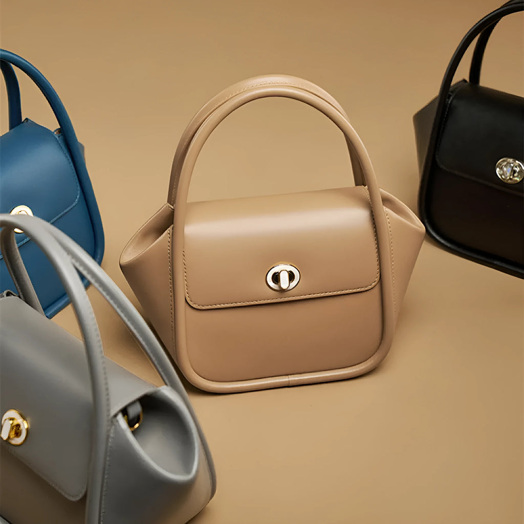 Women's wing-shaped leather tote bag with latch closure and cross-body strap in four colour options