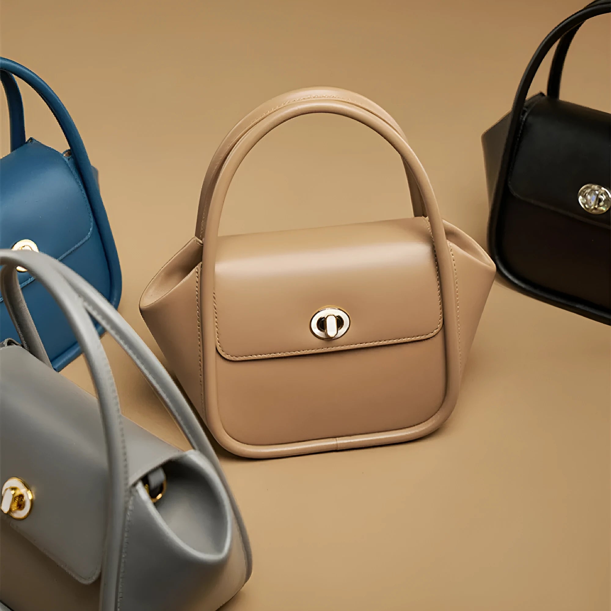 Women's wing-shaped leather tote bag with latch closure and cross-body strap in four colour options