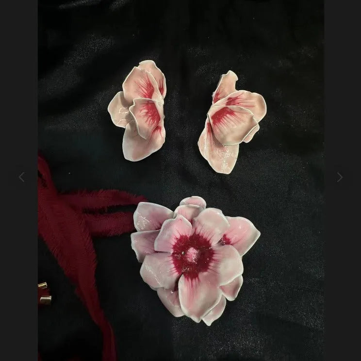 Close-up of pastoral style alloy flower stud earrings with oil-spot glaze in blue, green, purple, and rose colours