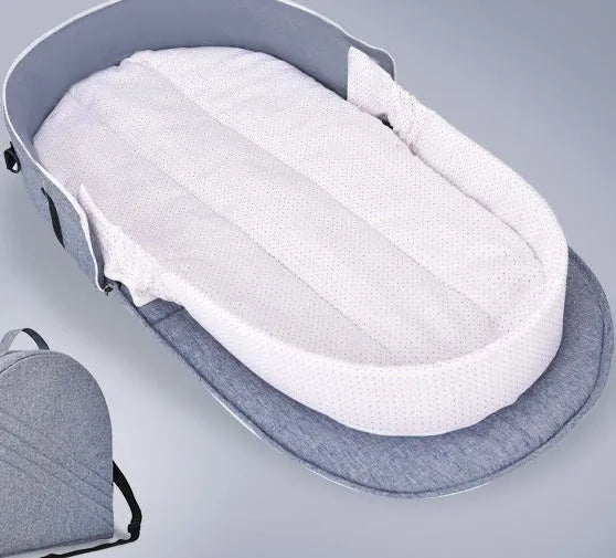Portable foldable baby anti-mosquito isolation bed with grey cotton linen fabric, open on a grassy area