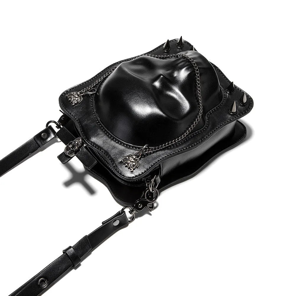 Black mini square messenger bag with embossed skull design, featuring stitching, rivets, chain details and zipper closure