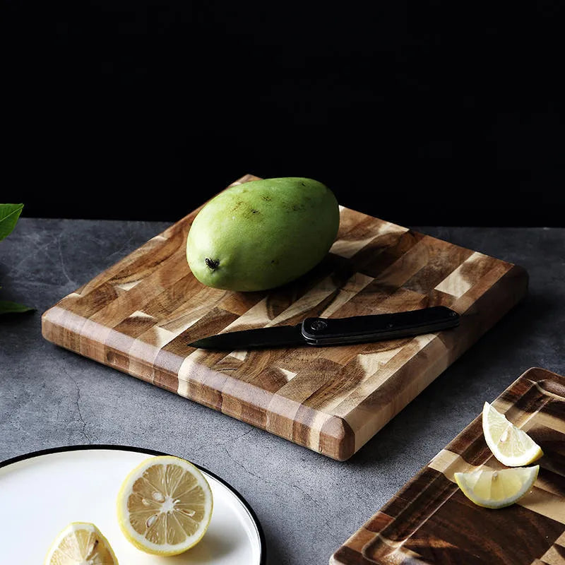 Brown solid acacia wood chopping board with 3cm thickness on a kitchen counter.