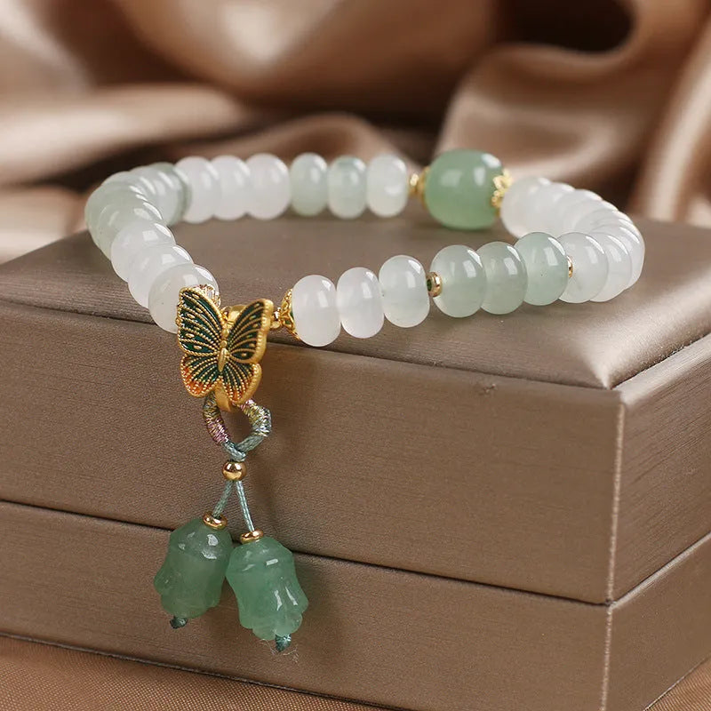 Green crystal Tian Shan Cui abacus bead bracelet with butterfly tassel, pearls and rhinestones.