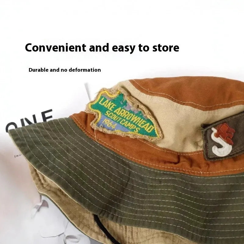 Army green cotton fisherman hat with patchwork details and flat-top crown, folded for display