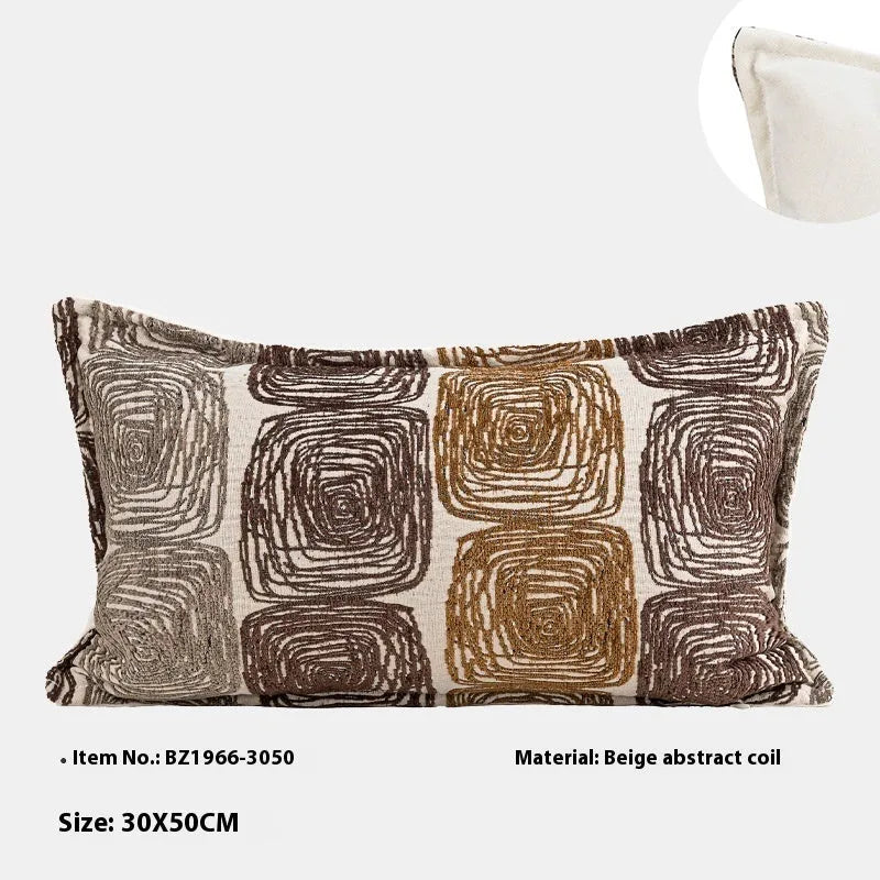 Cream and coffee abstract coil pattern pillow cover on a grey sofa