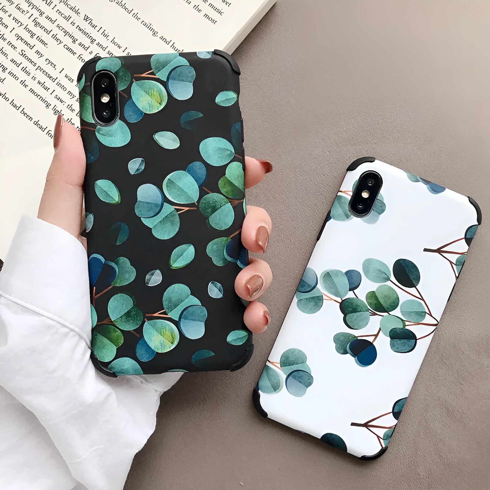 Black silicone iPhone case with a leaf pattern design on a table.