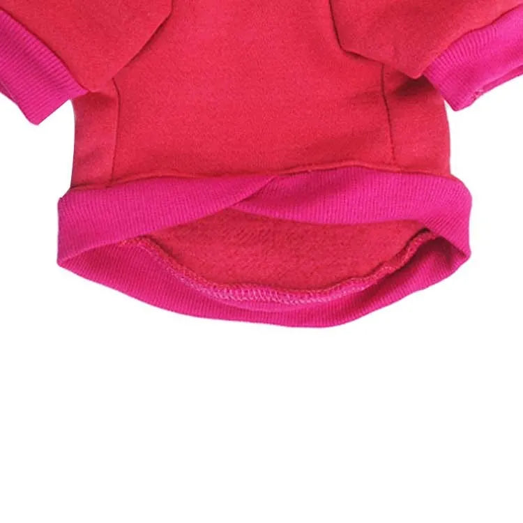 Small dog wearing a fleece hooded sweater in red, standing on a white background