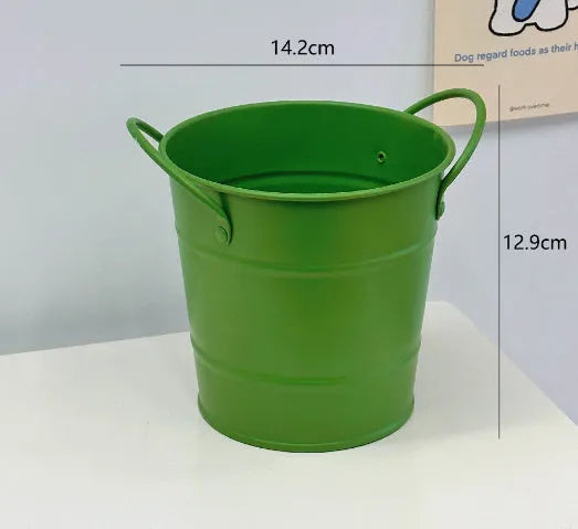 Round metal pen holder in a choice of colours including pink, green, red, white and yellow on a desk.