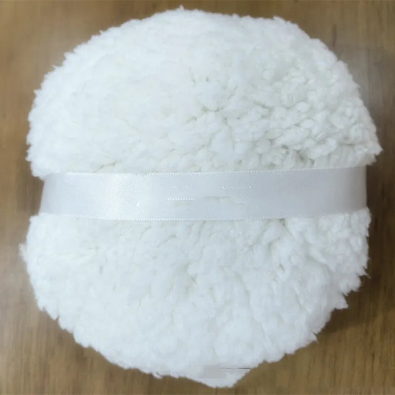 Oversized rectangular plush powder puff in white on a pink background.