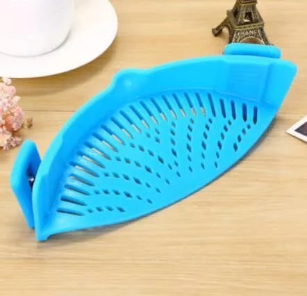 Silicone clip-on funnel strainer attached to a pot rim, showing hollow design and stainless steel buckle.